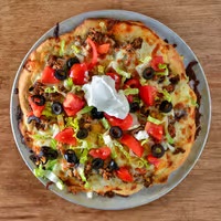 Casey's Toledo's specialty Taco Pizza in West Toledo features tomatoes, black olives and sour cream.